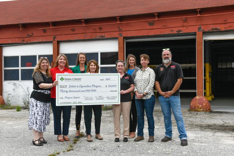 Group posing with large check